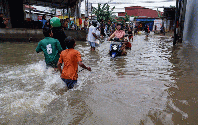 Warga melintasi banjir yang mengenangi Jalan Nipa-nipa di Kecamatan Manggala, Makassar, Sulawesi Selatan, Minggu (20/11/2022).