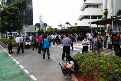 Sejumlah pekerja berhamburan keluar gedung setelah merasakan gempa di kawasan perkantoran di Jakarta, Senin (21/112022).