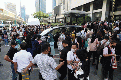 Sejumlah pekerja berhamburan keluar gedung setelah merasakan gempa di kawasan perkantoran di Jakarta, Senin (21/112022).