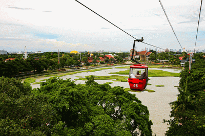 Pengunjung Taman Mini Indonesia Indah saat melihat lanskap Danau Archipelago dari atas Kereta Gantung di TMII, Jakarta, Minggu (20/11/2022).