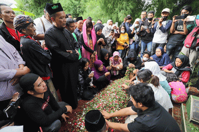 Keluarga dan kerabat menaburkan bunga saat prosesi pemakaman Agung Yulianto atau lebih dikenal Ki Joko Bodo di TPU Kober, Lubang Buaya, Jakarta Timur.