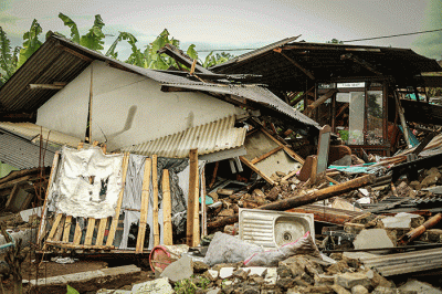 Seorang warga berfoto di depan rumah miliknya yang hancur akibat gempa di Kampung Barukaso, Desa Sukamulya, Kabupaten Cianjur, Jawa Barat, Rabu (23/11/2022).