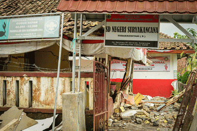 Seorang warga berfoto di depan rumah miliknya yang hancur akibat gempa di Kampung Barukaso, Desa Sukamulya, Kabupaten Cianjur, Jawa Barat, Rabu (23/11/2022).