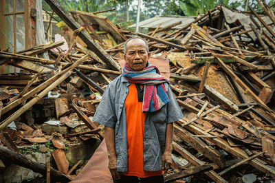 Seorang warga berfoto di depan rumah miliknya yang hancur akibat gempa di Kampung Barukaso, Desa Sukamulya, Kabupaten Cianjur, Jawa Barat, Rabu (23/11/2022).