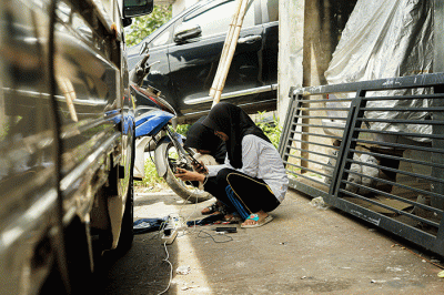 Sejumlah warga bergantian untuk mengisi daya ponselnya menggunakan genset keliling karena listrik masih padam imbas gempa bumi.