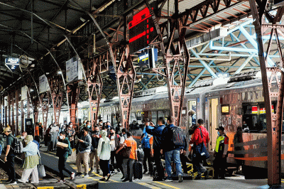 Para penumpang bersiap memasuki gerbong rangkaian kereta api di Stasiun Gambir, Jakarta, Jumat (25/11/2022).