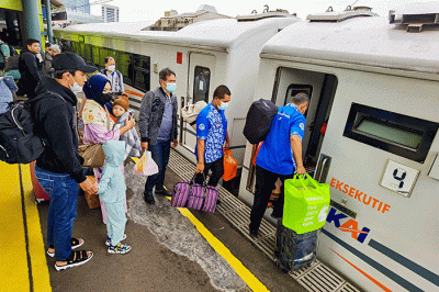 Para penumpang bersiap memasuki gerbong rangkaian kereta api di Stasiun Gambir, Jakarta, Jumat (25/11/2022).