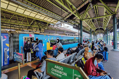 Para penumpang bersiap memasuki gerbong rangkaian kereta api di Stasiun Gambir, Jakarta, Jumat (25/11/2022).