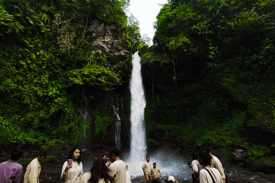 Pengunjung saat menikmati suasana keindahan air terjun curug Telu di lereng Gunung Slamet, Jawa Tengah, Minggu (27/11/2022).