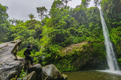 Pengunjung saat menikmati suasana keindahan air terjun curug Telu di lereng Gunung Slamet, Jawa Tengah, Minggu (27/11/2022).
