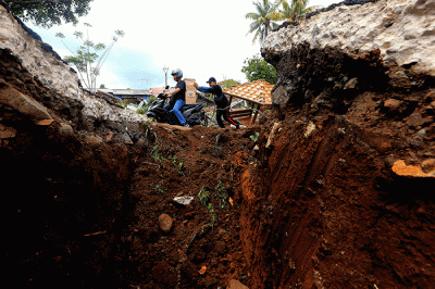 Warga melintasi area terdampak gempa di Sarampad, Kabupaten Cianjur, Jawa Barat, Minggu (27/11/2022).
