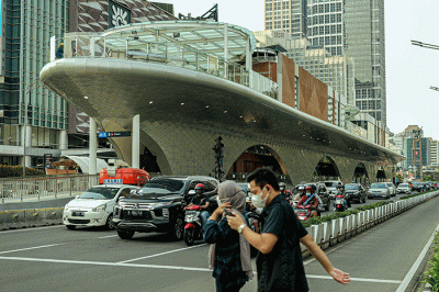 Sejumlah warga melintas di dekat proyek revitalisasi Halte Transjakarta Tosari yang hampir rampung di Jalan MH Thamrin, Jakarta Pusat, Minggu (27/11/2022).