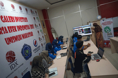 Warga tengah membuka situs Bursa Efek Indonesia untuk membuka tabungan saham syariah di Pantai Losari, Makassar.