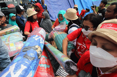Volunteer Karyawan Prudential Indonesia berbincang dengan korban gempa usai membagikan bantuan di Desa Sukamulya, Cugenang, Kabupaten Cianjur.