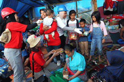 Volunteer Karyawan Prudential Indonesia berbincang dengan korban gempa usai membagikan bantuan di Desa Sukamulya, Cugenang, Kabupaten Cianjur.