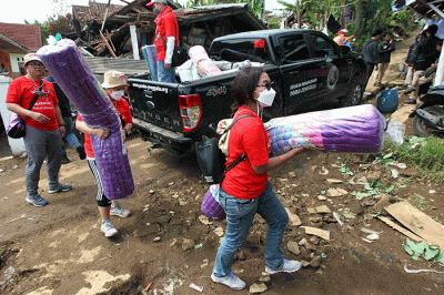 Volunteer Karyawan Prudential Indonesia berbincang dengan korban gempa usai membagikan bantuan di Desa Sukamulya, Cugenang, Kabupaten Cianjur.