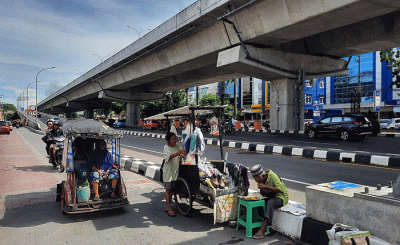 Warga melintas di kawasan pembangunan Jalan Tol Layang di Makassar, Rabu (30/11/2022).