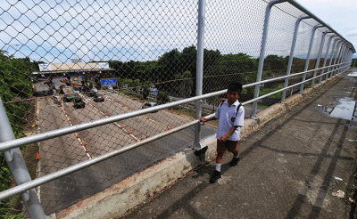 Warga melintas di kawasan pembangunan Jalan Tol Layang di Makassar, Rabu (30/11/2022).
