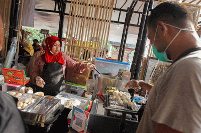 Penjual menunjukkan pempek jualannya dalam acara Expo Pempek 2022 di Mal Sarinah, Jakarta Pusat, Jumat (2/12/2022).