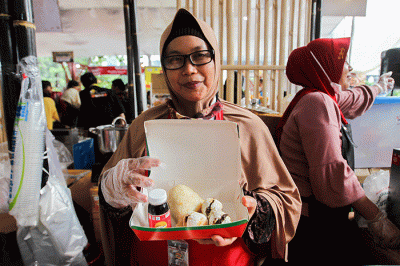 Penjual menunjukkan pempek jualannya dalam acara Expo Pempek 2022 di Mal Sarinah, Jakarta Pusat, Jumat (2/12/2022).