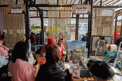 Penjual menunjukkan pempek jualannya dalam acara Expo Pempek 2022 di Mal Sarinah, Jakarta Pusat, Jumat (2/12/2022).
