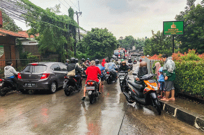 Pengendara motor nekat menerobos banjir di Jalan Radar Auri, Cimanggis, Depok, Jawa Barat, Senin (5/12/2022).