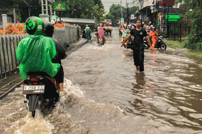 Pengendara motor nekat menerobos banjir di Jalan Radar Auri, Cimanggis, Depok, Jawa Barat, Senin (5/12/2022).
