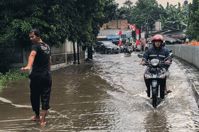 Pengendara motor nekat menerobos banjir di Jalan Radar Auri, Cimanggis, Depok, Jawa Barat, Senin (5/12/2022).