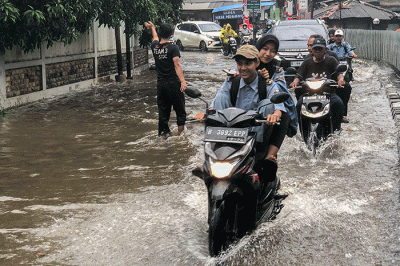 Pengendara motor nekat menerobos banjir di Jalan Radar Auri, Cimanggis, Depok, Jawa Barat, Senin (5/12/2022).