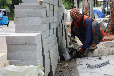 Pekerja saat menyelesaikan proyek revitalisasi trotoar di kawasan Jalan Medan Merdeka, Jakarta, Selasa (6/12/2022).