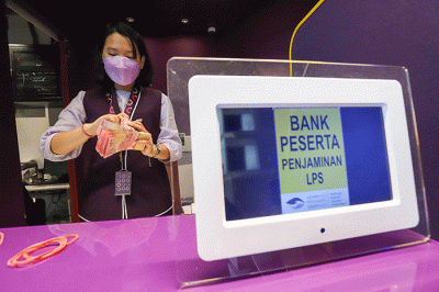 Petugas menghitung uang pecahan rupiah di Jakarta, Rabu (7/12/2022).