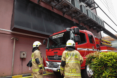 Sejumlah petugas Pemadam Kebakaran (Damkar) melintas usai terjadi kebakaran di depan gedung Imigrasi Kantor Kementerian Hukum dan Hak Asasi Manusia.