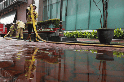 Sejumlah petugas Pemadam Kebakaran (Damkar) melintas usai terjadi kebakaran di depan gedung Imigrasi Kantor Kementerian Hukum dan Hak Asasi Manusia.