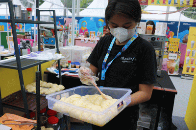 Pengunjung memesan menu makanan di Loffee Croffle & Coffe di pameran Wirausaha Muda Mandiri (WMM) Fest 2022 di Plaza Barat Senayan, Jakarta, Sabtu (10/12/2022).