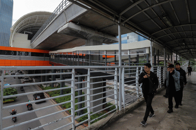Warga melintas didekat proyek Stasiun Lintas Raya Terpadu (LRT) Rasuna Said, Kuningan, Jakarta Selatan, Rabu (14/12/2022).