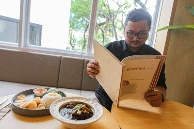Pengunjung saat menikmati makanan di Bermvda Cafe & Eatery, One Satrio, Jakarta Selatan, Minggu (18/12/2022).