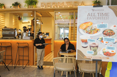 Pengunjung saat menikmati makanan di Bermvda Cafe & Eatery, One Satrio, Jakarta Selatan, Minggu (18/12/2022).