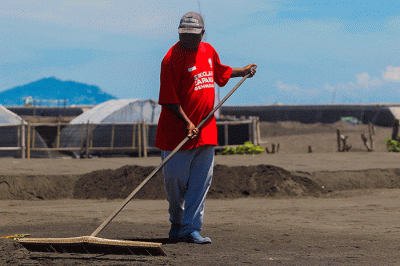 Petani saat merapikan ladang garam setelah disiram air laut di Desa Kusamba, Bali, Selasa (20/12/2022).