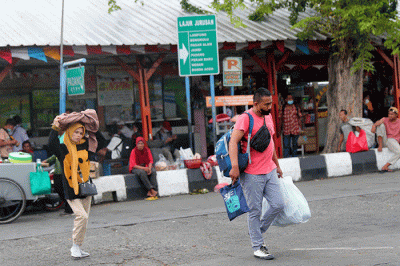 Penumpang berjalan menuju bus antarkota antarprovinsi (AKAP) di Terminal Kalideres, Jakarta Barat, Rabu (21/12/2022).