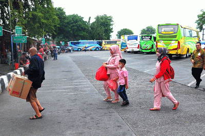 Penumpang berjalan menuju bus antarkota antarprovinsi (AKAP) di Terminal Kalideres, Jakarta Barat, Rabu (21/12/2022).