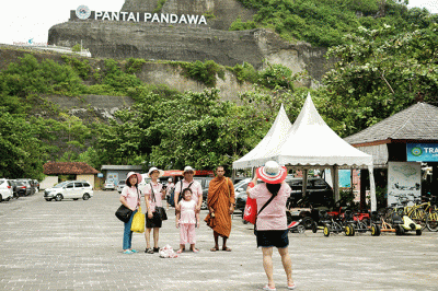 Wisatawan berswafoto di Pantai Pandawa, Kuta Selatan, Bali, Rabu (21/12/2022).