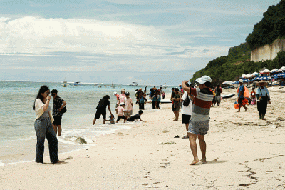 Wisatawan berswafoto di Pantai Pandawa, Kuta Selatan, Bali, Rabu (21/12/2022).