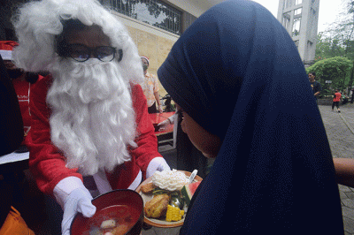 Ibu-ibu relawan Piring Kasih berbagi makan siang gratis kepada masyarakat di pelataran Gereja St Theresia Bongsari Semarang, Jawa Tengah, Kamis (22/12/2022).