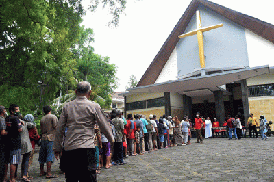 Ibu-ibu relawan Piring Kasih berbagi makan siang gratis kepada masyarakat di pelataran Gereja St Theresia Bongsari Semarang, Jawa Tengah, Kamis (22/12/2022).