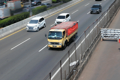 Sejumlah kendaraan berat pengangkut barang melintas di ruas tol Tangerang-Merak di Tangerang, Banten, Jumat (23/12/2022).