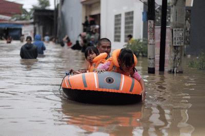 Sejumlah warga melewati banjir di Jalan Poros Nipa Nipa Antang, Makassar, Minggu (25/12/2022).