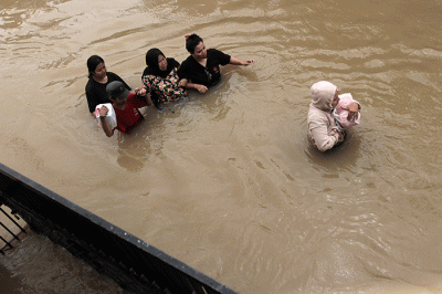 Sejumlah warga melewati banjir di Jalan Poros Nipa Nipa Antang, Makassar, Minggu (25/12/2022).