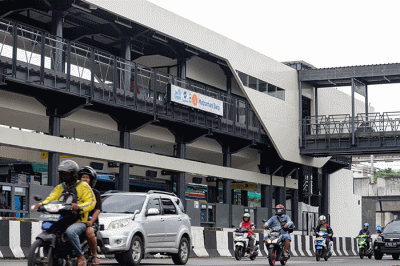 Pengendara melintas di Halte Transjakarta Matraman Baru, Jakarta Timur, Senin (26/12/2022).