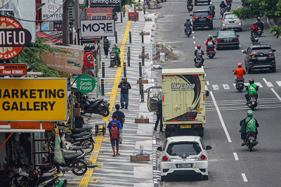 Pejalan kaki melintas di trotoar yang direvitalisasi di Jalan Margonda Raya, Depok, Jawa barat, Senin (26/12/2022).
