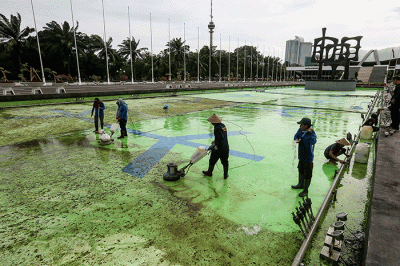 Pekerja membersihkan kolam air mancur di halaman depan Gedung Parlemen MPR/DPR-DPD, Senayan, Jakarta, Selasa (27/12/2022).